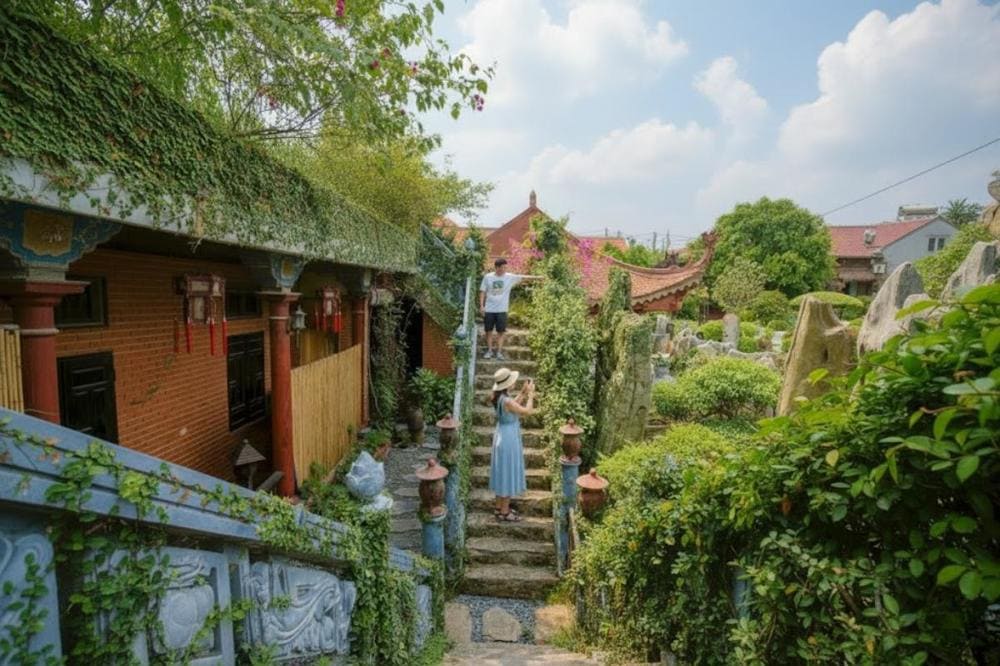 Cầu thang đá tự nhiên, xung quanh có nhiều cây cảnh xanh mướt, mang đến cảm giác bình yên, gần gũi với thiên nhiên.